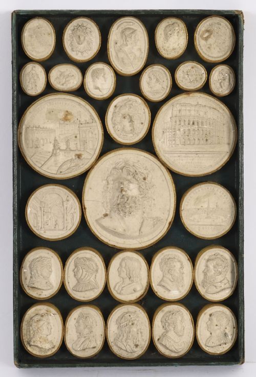 fig 2. An 18th-century boxed set of cream plaster Grand Tour intaglios showing classical profile portraits and Roman architectural scenes alongside an Italian manuscript index.