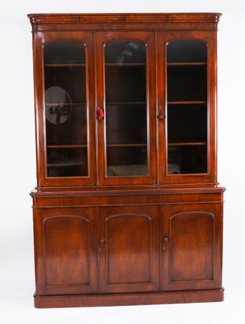 fig 1. A large 19th-century Victorian flame mahogany library bookcase featuring a glazed three-door upper section filled with books above a solid three-door cupboard base.