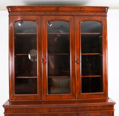 fig 2. A large 19th-century Victorian flame mahogany library bookcase featuring a glazed three-door upper section filled with books above a solid three-door cupboard base.