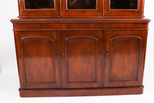 fig 4. A large 19th-century Victorian flame mahogany library bookcase featuring a glazed three-door upper section filled with books above a solid three-door cupboard base.