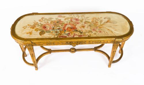fig 2. An early 20th-century oval French Louis XVI style giltwood low table featuring an inlaid tapestry top under glass and carved legs connected by a stretcher.