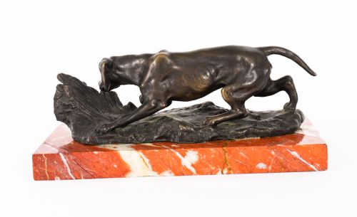 fig 1. A dark brown patinated bronze sculpture of a hunting dog stalking prey, mounted on a rectangular red and white veined marble base.