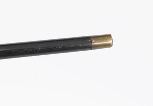 fig 4. An antique walking stick featuring a relief-carved silver handle decorated with prunus blossoms, set on a slender black ebonised wooden shaft with a brass tip.