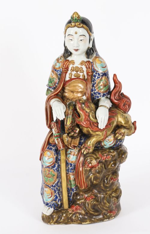 fig 1. An antique Japanese Kutani porcelain sculpture depicting Guanyin standing beside a shishi lion with detailed polychrome drapery and gold leaf accents.