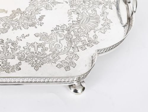 fig 4. An Edwardian silver-plated gallery tray featuring a pierced rim, engraved foliate scrollwork, twin handles, and ball feet.