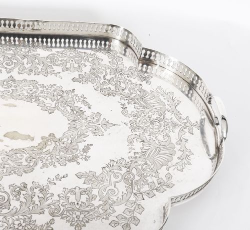 fig 5. An Edwardian silver-plated gallery tray featuring a pierced rim, engraved foliate scrollwork, twin handles, and ball feet.