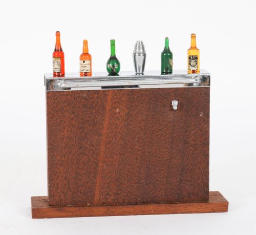 fig 1. An Art Deco wooden cocktail stick holder featuring miniature liquor bottle handles and a central cocktail shaker pick atop a chrome-trimmed base.
