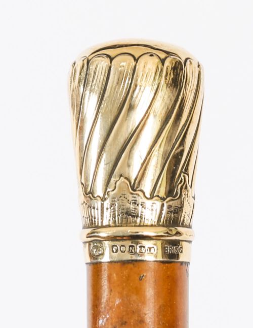 A straight polished wooden walking cane featuring a decorated 18ct gold pommel handle and a metal ferrule tip at the base. View IV