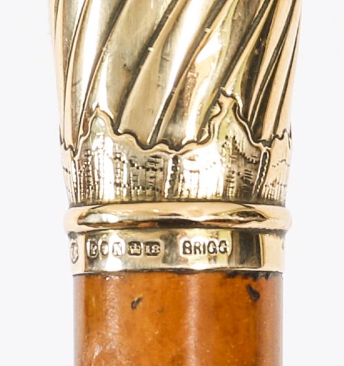 A straight polished wooden walking cane featuring a decorated 18ct gold pommel handle and a metal ferrule tip at the base. View VII