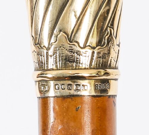A straight polished wooden walking cane featuring a decorated 18ct gold pommel handle and a metal ferrule tip at the base. View VIII