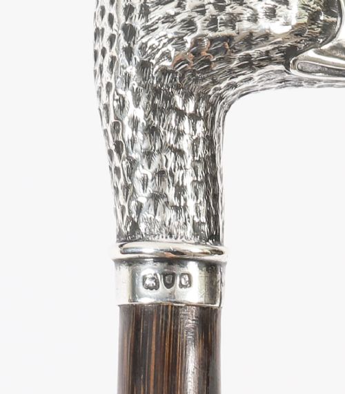 An antique walking stick featuring a dark polished wooden shaft topped with a cast silver duck head handle. View IV