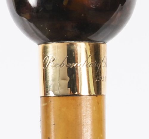 An antique Victorian wooden walking stick featuring a dark spherical pommel, an 18ct gold collar band, and a tapered brown shaft. View VIII
