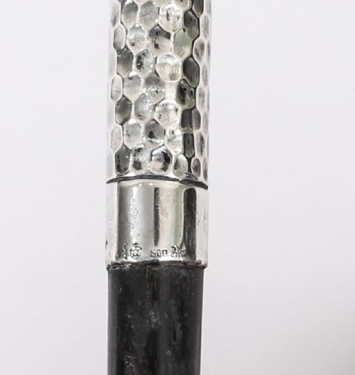 An antique French walking cane featuring a hand-hammered crook-shaped silver handle mounted on a dark wooden shaft. View VII