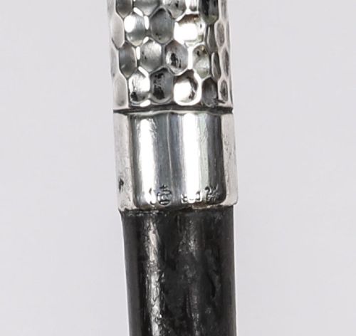An antique French walking cane featuring a hand-hammered crook-shaped silver handle mounted on a dark wooden shaft. View VIII