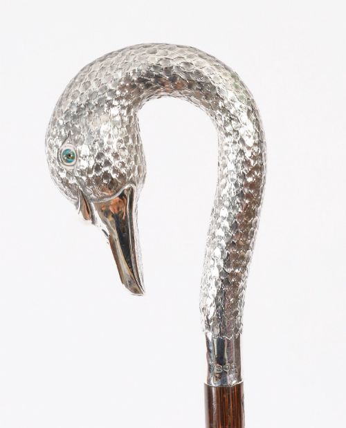 fig 2. An Edwardian walking stick featuring a sterling silver swan head handle mounted on a dark wood shaft.