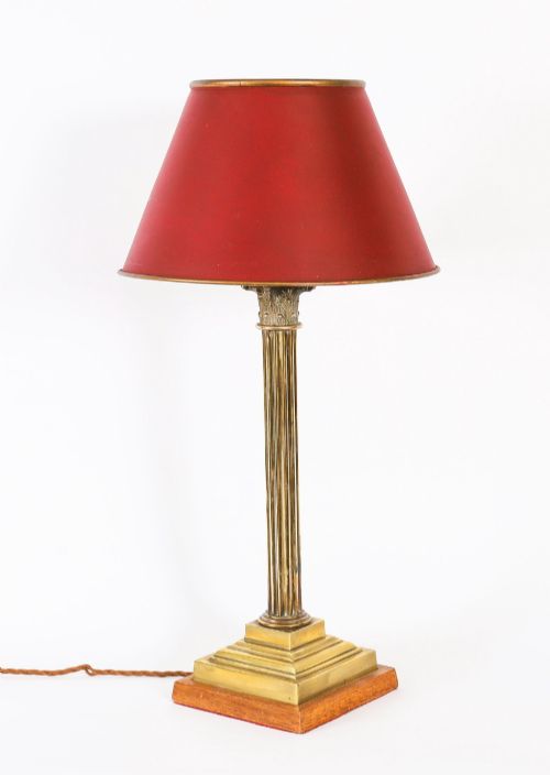 fig 1. A pair of late nineteenth-century brass Corinthian column table lamps featuring fluted stems, stepped bases, wooden plinths, and conical red lampshades.