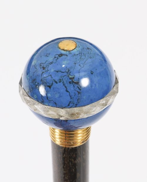 fig 2. An Edwardian walking cane featuring a spherical lapis lazuli pommel accented with a faceted crystal band and a ribbed gold collar on a dark hardwood shaft.