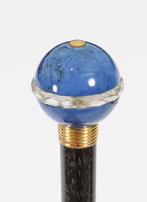 fig 6. An Edwardian walking cane featuring a spherical lapis lazuli pommel accented with a faceted crystal band and a ribbed gold collar on a dark hardwood shaft.