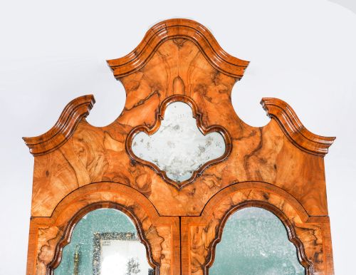 fig 3. An 18th-century Venetian burr walnut bureau bookcase featuring a shaped top pediment with mirrored inset, twin mirrored cabinet doors, a slant-front writing slope, and three serpentine drawers.