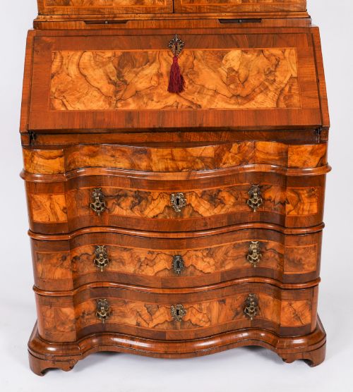 fig 4. An 18th-century Venetian burr walnut bureau bookcase featuring a shaped top pediment with mirrored inset, twin mirrored cabinet doors, a slant-front writing slope, and three serpentine drawers.