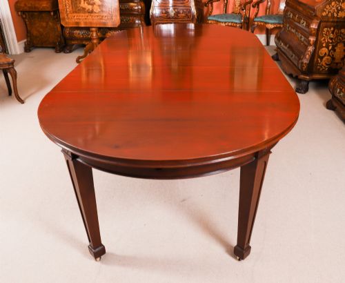 fig 1. An antique Victorian oval extending dining table crafted from flame mahogany with tapered legs on brass castors.