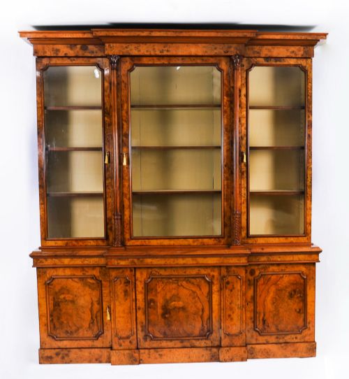 fig 1. A mid-19th-century Victorian burr walnut breakfront bookcase featuring three upper glazed doors, turned pilasters, and three lower panelled cupboard doors.