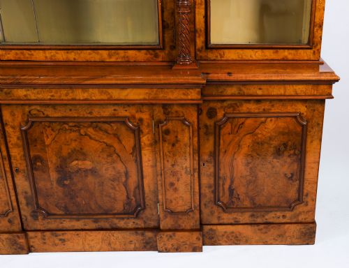 fig 3. A mid-19th-century Victorian burr walnut breakfront bookcase featuring three upper glazed doors, turned pilasters, and three lower panelled cupboard doors.