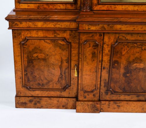 fig 5. A mid-19th-century Victorian burr walnut breakfront bookcase featuring three upper glazed doors, turned pilasters, and three lower panelled cupboard doors.