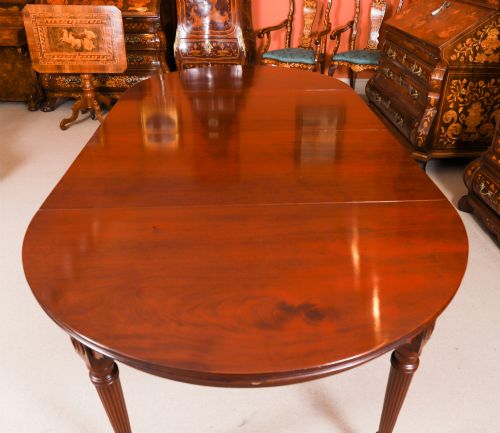 fig 4. An antique Victorian flame mahogany extending dining table with fluted tapering legs set on brass castors.