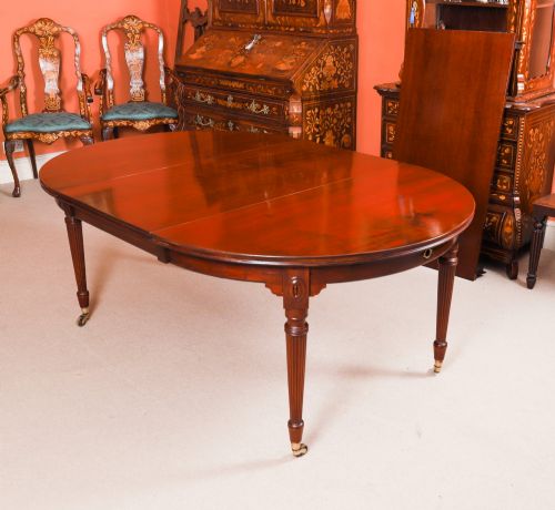 fig 7. An antique Victorian flame mahogany extending dining table with fluted tapering legs set on brass castors.