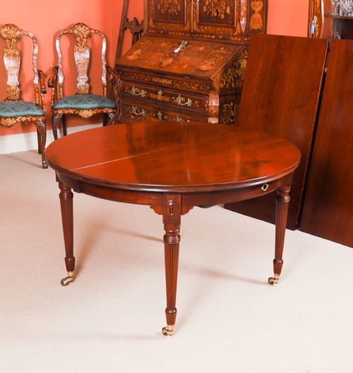 fig 8. An antique Victorian flame mahogany extending dining table with fluted tapering legs set on brass castors.