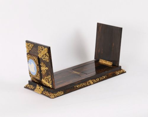 fig 8. A three-piece Victorian coromandel wood desk set featuring gilt ormolu mounts, brass strapwork, and light blue oval jasperware plaques.