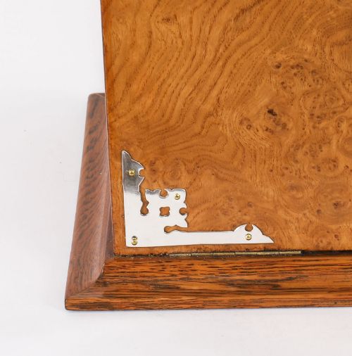 fig 9. A 19th-century Victorian figured oak three-bottle tantalus open to reveal three cut glass decanters, a fitted cribbage board, and a drop-front drawer containing a silver-plated tray and playing cards.