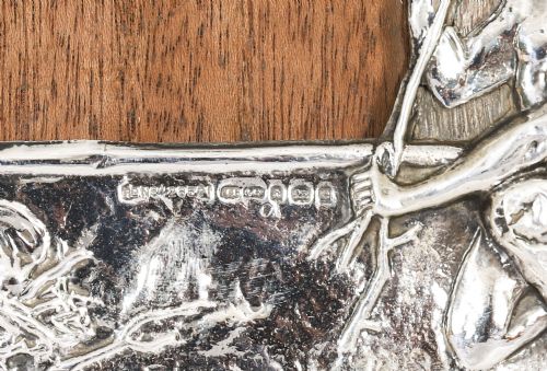 fig 6. An Edwardian sterling silver picture frame featuring an embossed relief scene of Hiawatha with a wooden backing.