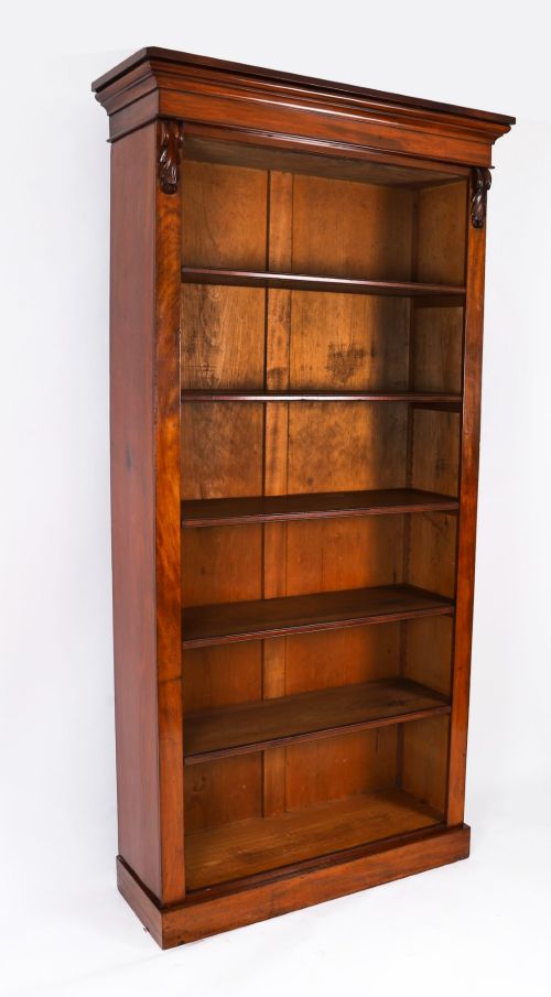 fig 1. A tall Victorian mahogany open bookcase featuring six tiers of adjustable shelves, flanked by decorative carved corbels under a projected cornice.