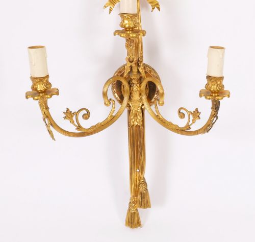 fig 2. A pair of 19th-century French gilt bronze three-branch wall sconces styled with ribbon bow tops and tassel finials.