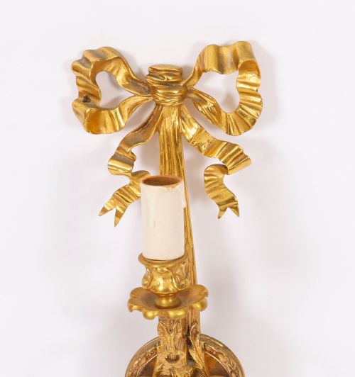 fig 3. A pair of 19th-century French gilt bronze three-branch wall sconces styled with ribbon bow tops and tassel finials.