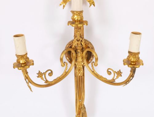 fig 4. Set of four gilt bronze three-branch wall lights featuring ribbon bow cresting and hanging tassel drops.