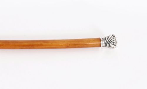 fig 4. Victorian walking cane featuring an engraved sterling silver pommel with spiralled fluting mounted on a light wood shaft.