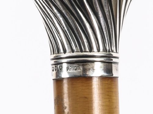 Victorian walking cane featuring an engraved sterling silver pommel with spiralled fluting mounted on a light wood shaft. View XII
