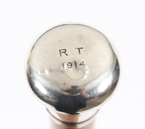 fig 4. An Edwardian walking stick featuring a smooth domed sterling silver pommel and a polished wooden shaft.