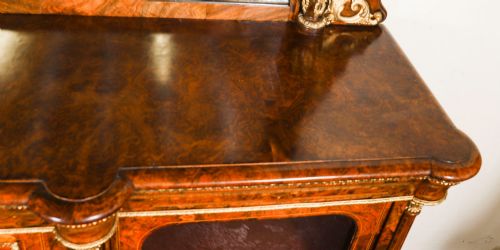 fig 5. A nineteenth-century Victorian burr walnut credenza featuring an arched mirror back, glazed side doors, and a central cupboard inlaid with a porcelain plaque.