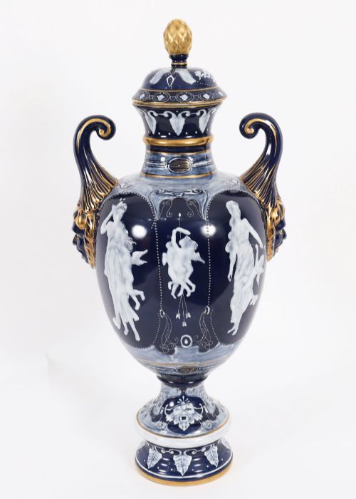 fig 1. A pair of cobalt blue and white porcelain lidded vases featuring classical figures, scrolling handles, and gilded finials.