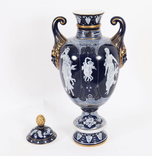 fig 2. A pair of cobalt blue and white porcelain lidded vases featuring classical figures, scrolling handles, and gilded finials.