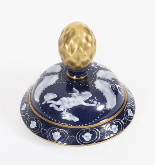 fig 3. A pair of cobalt blue and white porcelain lidded vases featuring classical figures, scrolling handles, and gilded finials.