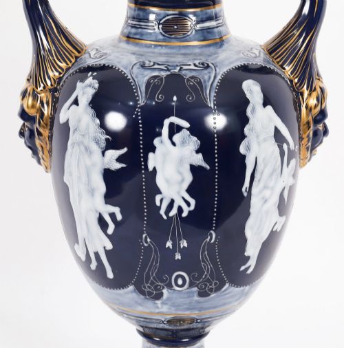 fig 5. A pair of cobalt blue and white porcelain lidded vases featuring classical figures, scrolling handles, and gilded finials.