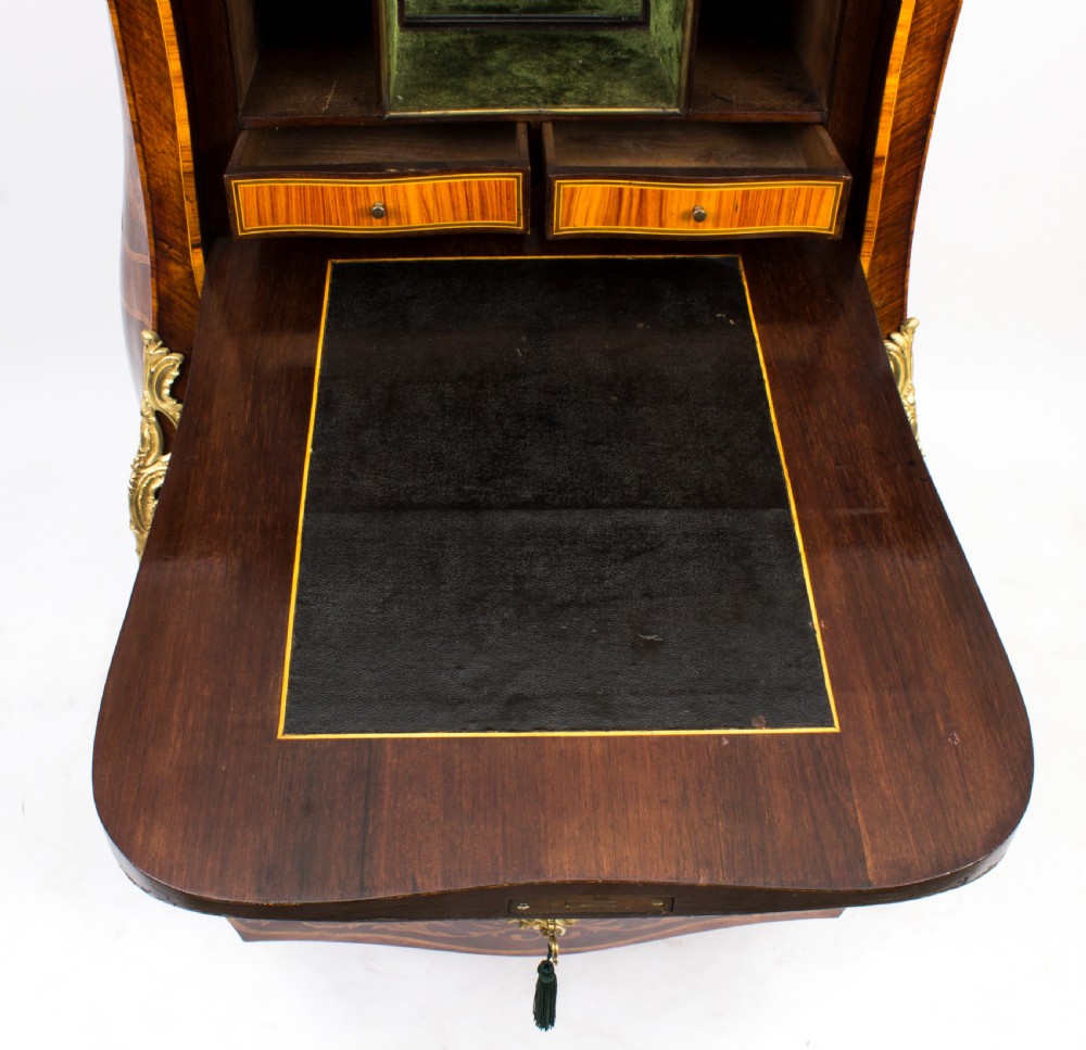 A 19th-century French Rococo Revival secretaire a abattant crafted with floral marquetry, gilt bronze mounts, a contoured silhouette, and a marble top. View XV