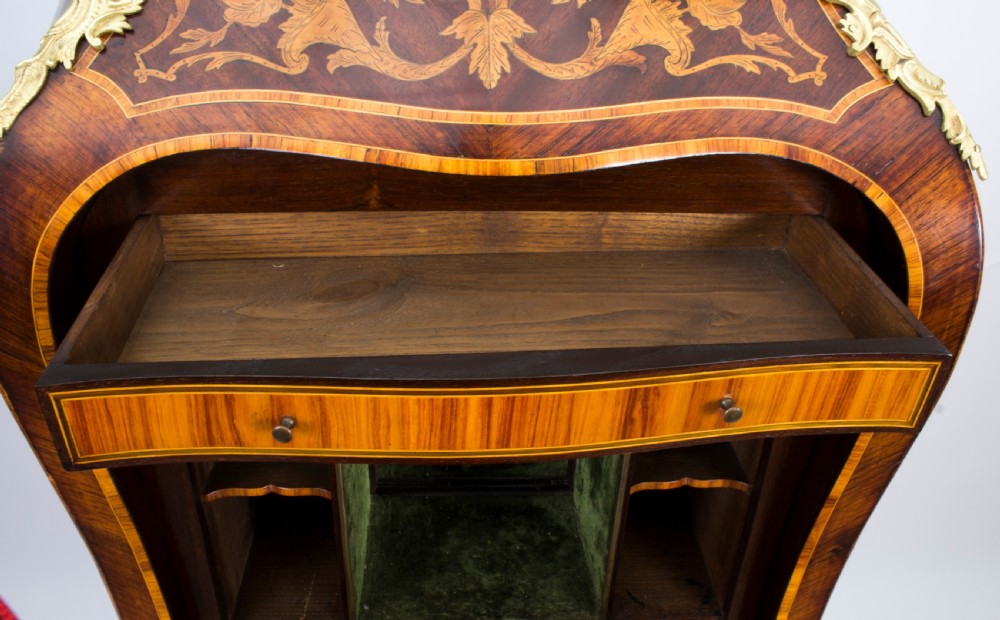 A 19th-century French Rococo Revival secretaire a abattant crafted with floral marquetry, gilt bronze mounts, a contoured silhouette, and a marble top. View XVI