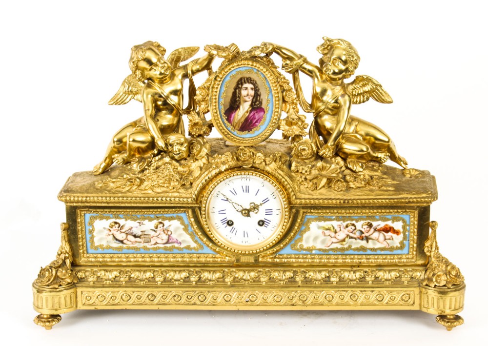 An 19th-century French gilt bronze mantel clock with two winged cherubs flanking an oval portrait plaque of Moliere above a porcelain dial.