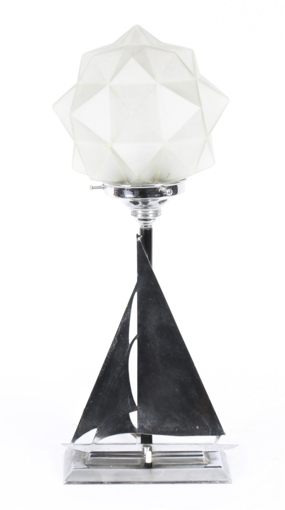 An Art Deco chrome table lamp featuring a stylized sailboat stem set upon a stepped rectangular base, topped with a faceted frosted glass shade.